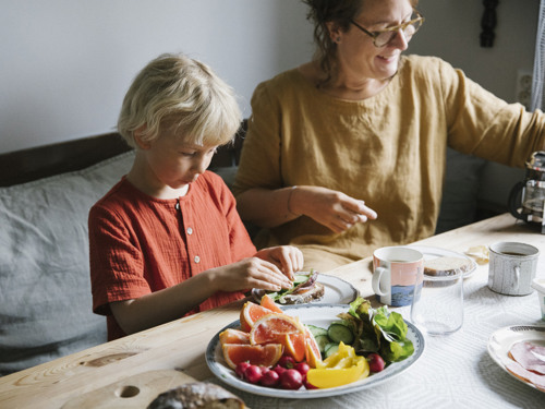 Flicka och kvinna vid frukostbord.