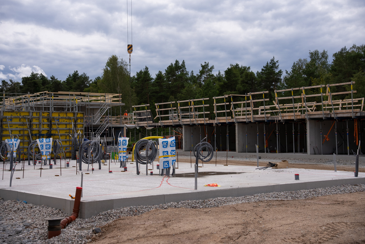 En byggnad under uppförande med en lyftkran i bakgrunden.